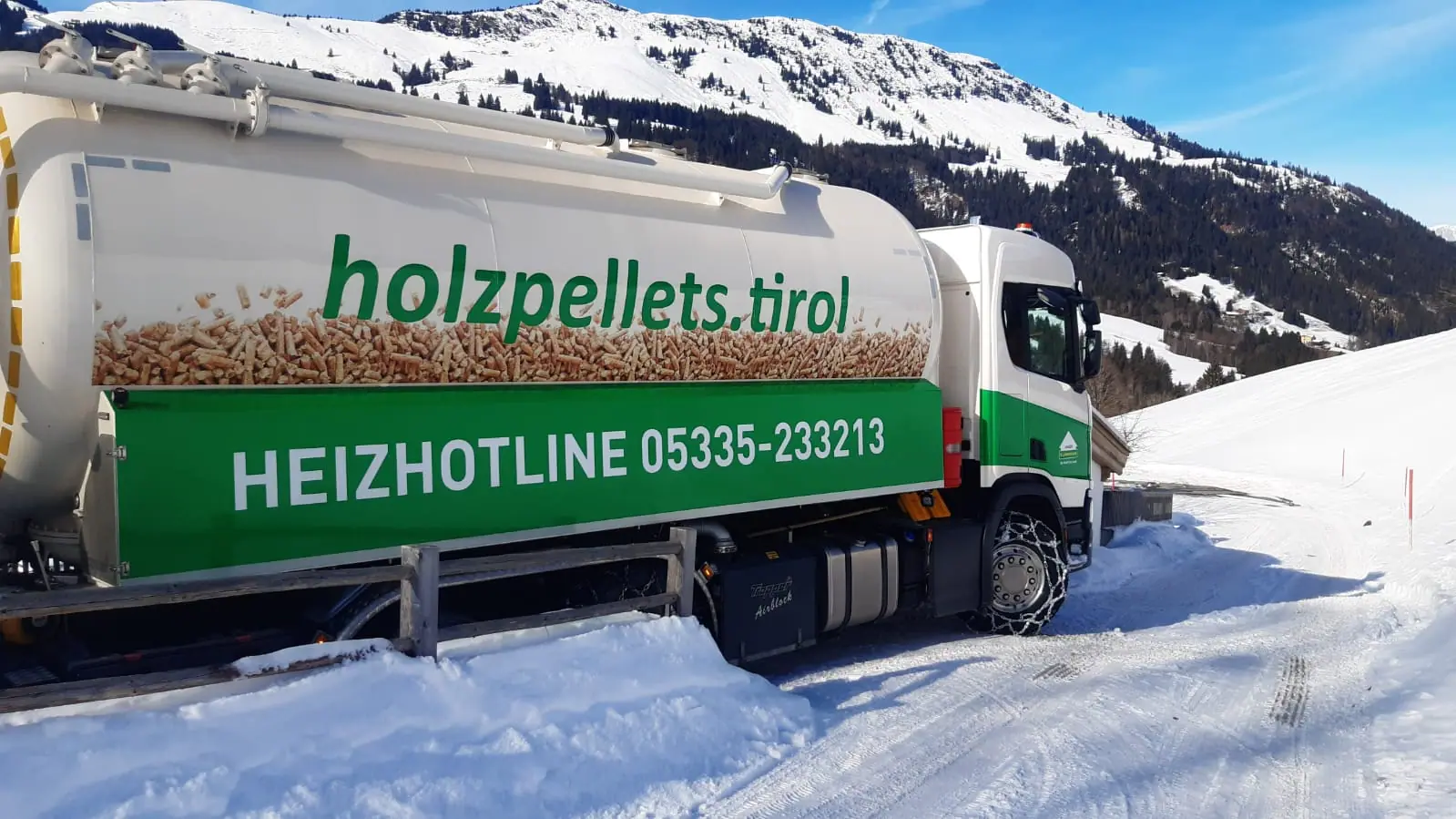 Pellets-Tankwagen mit der Aufschrift holzpellets.tirol auf einer verschneiten Bergstraße